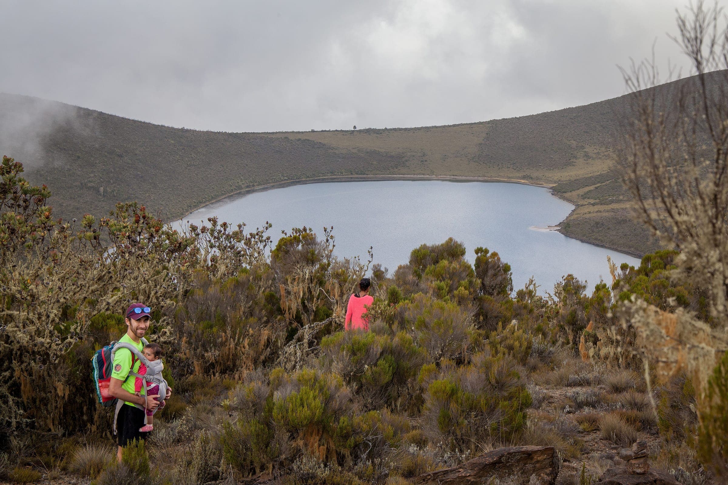 A hiker on the crater rim with Lake Alice below